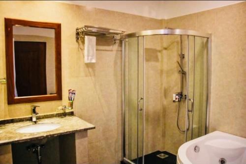 a bathroom with a shower and a sink at Kolonne RIverside Garden Hotel in Avissawella