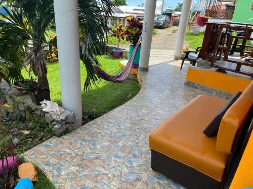 a couch sitting on a patio with a hammock at Posada Ashanty in Providencia