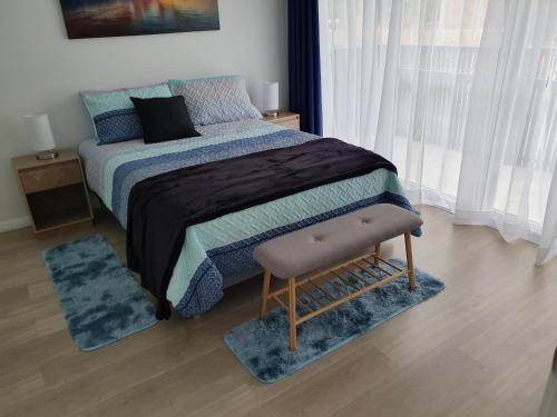 a bedroom with a bed with blue blankets and pillows at Townhouses by the Beach in Thirroul