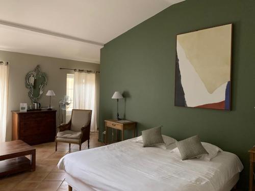 1 dormitorio con 1 cama blanca grande y 1 silla en Hôtel de Mirmande, en Mirmande