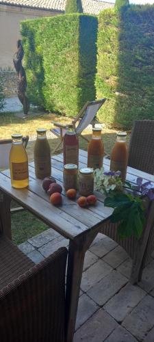 Hôtel de Mirmande في ميرماند: طاولة خشبية عليها جرار وطعام