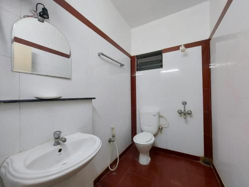 a bathroom with a white sink and a toilet at Mira International in Digha