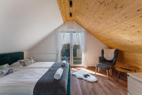 a bedroom with a bed and a chair and a window at Domek nad zalewem in Czorsztyn