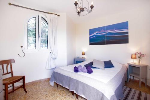 Un dormitorio con una cama con zapatos morados. en La Tourrette en Tourrettes-sur-Loup