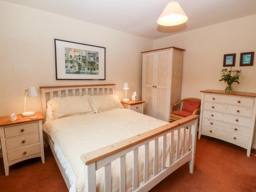 - une chambre avec un lit, une armoire et une chaise dans l'établissement Hefo'r Grug, à Pwllheli