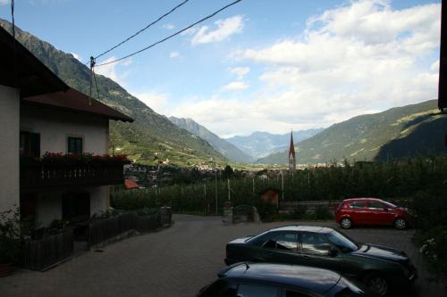 zwei Autos auf einem Parkplatz mit Bergen im Hintergrund geparkt in der Unterkunft Gaulbachhof in Naturns