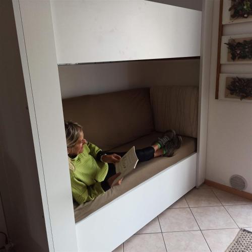 a little girl sitting on a bed in a box at Juli Richi apartment in Croviana