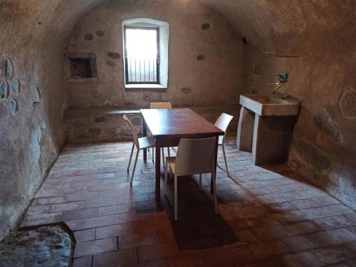 a table and chairs in a room with a window at Juli Richi apartment in Croviana