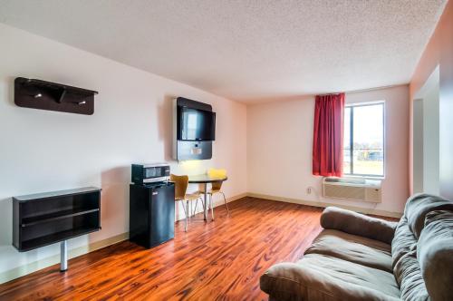 a living room with a couch and a television at Motel 6-Lansing, IL - Chicago South in Lansing