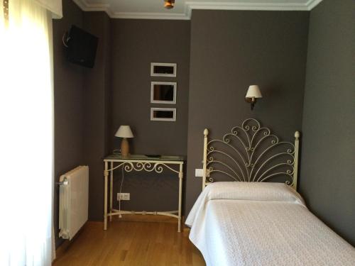 een slaapkamer met een bed en een tafel met een lamp bij El Porton de la Huebra in Vecinos