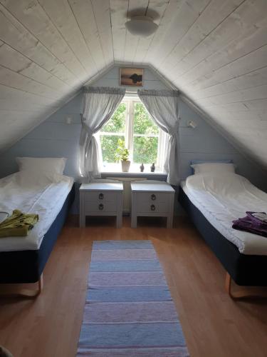 a attic bedroom with two beds and a window at Carlberg Rum Loftet in Bergshamra