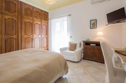 a bedroom with a bed and a chair and a television at B&B Mamma Rosa Positano in Positano