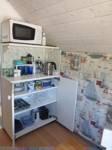 a small kitchen with a microwave and a refrigerator at Carlberg Rum Loftet in Bergshamra