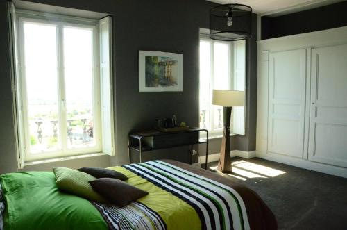 een slaapkamer met een bed en 2 ramen bij La Lit'Hote in Mirefleurs