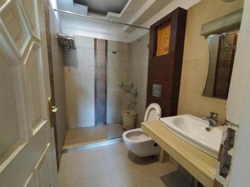 y baño con aseo, lavabo y ducha. en Hotel Sukhakarta, Nagpur, en Nagpur