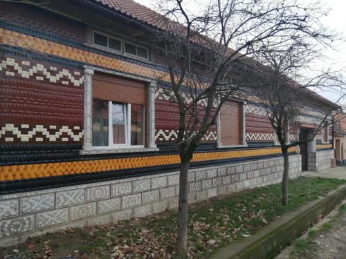 a building with a tree in front of it at Borlova /Muntele Mic in Borlova