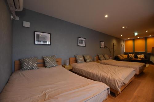 a room with two beds and a couch at PrimeRoom Beppu Asami in Beppu