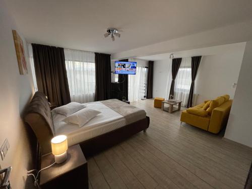 a bedroom with a bed and a couch and a tv at Casa Valentina in Cristian