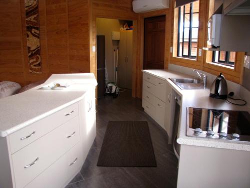 a kitchen with white cabinets and a sink at Ngauruhoe Yurt - Ohakune Holiday Home in Ohakune