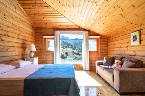 a bedroom with a bed and a couch and a window at Luxury Chalet Vila on Mountain Top with great view in Kalavrita