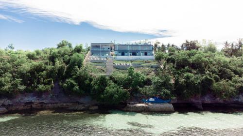 a house on a hill next to a body of water at Epic Suites Bohol ADULTS ONLY in Dauis