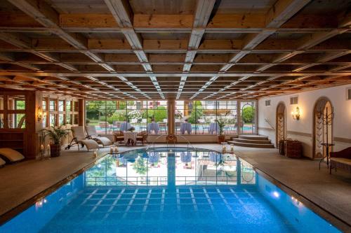 a pool in a house with a large ceiling at Romantik Hotel Oberwirt in Marlengo