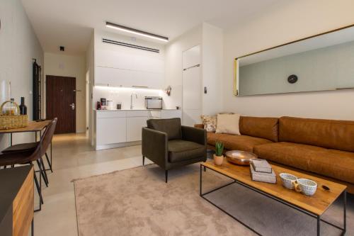 ein Wohnzimmer mit einem Sofa und einem Tisch in der Unterkunft Aphrodite Suite in Aschkelon