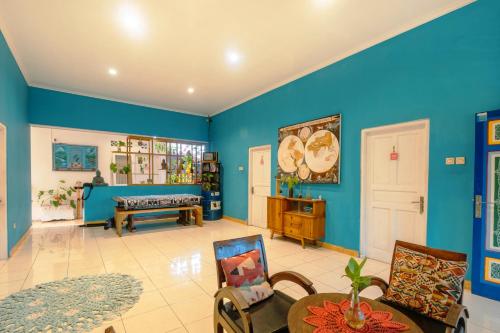 a living room with blue walls and a table and chairs at Happy Buddha Yogyakarta in Yogyakarta