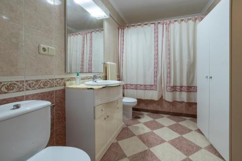 y baño con aseo, lavabo y espejo. en CASA LA TERCIA, en Herencia