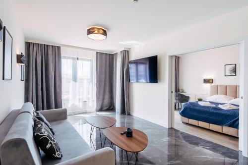 a living room with a couch and a bed at Apartament Baltic Plaza 316 in Kołobrzeg