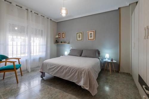 1 dormitorio con 1 cama, 1 silla y 1 ventana en CASA LA TERCIA, en Herencia