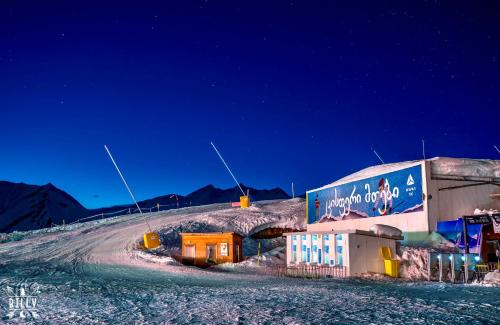 a building on a snow covered hill at night at New Gudauri Twins Mountain view in Gudauri