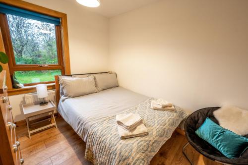 a small bedroom with a bed and a window at Coorie View in Kilmore