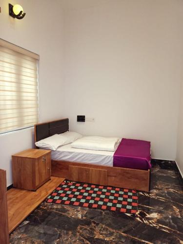 a bedroom with a bed and a checkered rug at Divine View Holyday Home (Homestay) in Kalpetta
