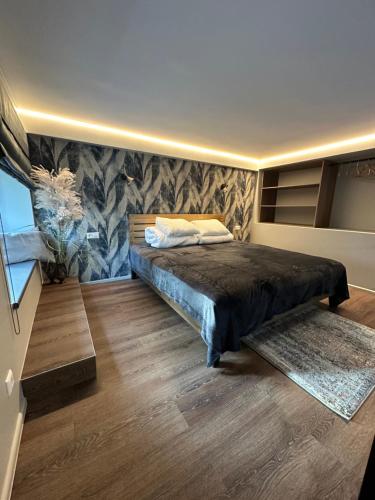 sypialnia z dużym łóżkiem i drewnianą podłogą w obiekcie Daukanto 5 w Kownie