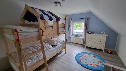 a bedroom with two bunk beds and a window at Nordseeblick 2 in Carolinensiel