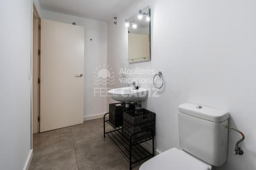 a bathroom with a white toilet and a sink at Apartamento El Mirador del Paso (Feel Cádiz) in Cádiz