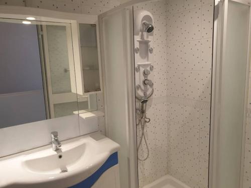 a bathroom with a sink and a shower with a mirror at Joli duplex à Hammamet dans résidence avec piscine in Hammamet