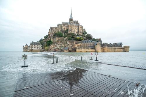 Maison proche Mont Saint Michel في بوفوار: جزيرة في الماء عليها قلعة