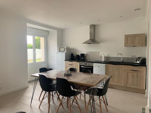 une cuisine avec une table et des chaises dans une pièce dans l'établissement Maison proche Mont Saint Michel, à Beauvoir
