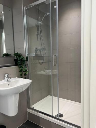 a bathroom with a shower and a sink at 2 bedroom with big balcony and gym in Manchester