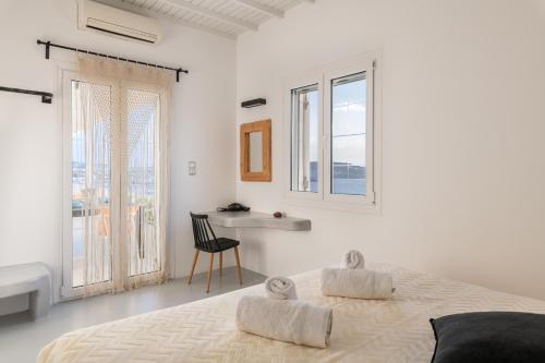 una camera bianca con letto e scrivania di Yalos mykonos 3 bedroom Luxury home in Mykonos Town with Sea & Sunset view a Tagou