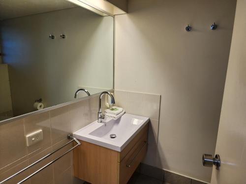 a bathroom with a sink and a large mirror at Hume Inn Motel Albury CBD in Albury
