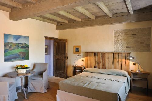 una camera da letto con un letto e un tavolo con una sedia di Casapecchenino a Dogliani