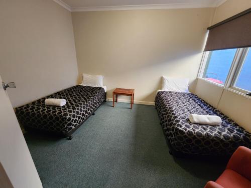 a hotel room with two beds and a window at Hume Inn Motel Albury CBD in Albury
