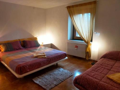 a bedroom with a bed and a window and a couch at Appartamento bilocale- Il nido sui tetti di Varese in Varese