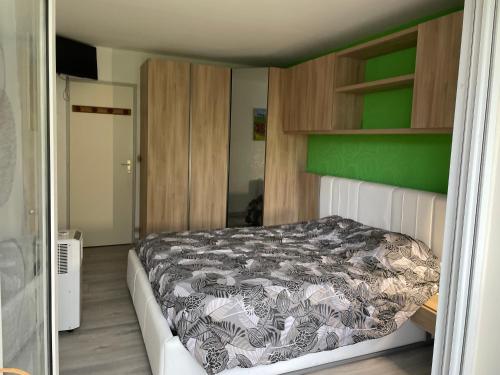 サン・ブルヴァン・レ・パンにあるRésidence le freeport2の緑の壁、ベッド付きのベッドルーム1室