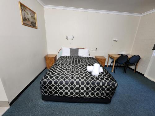 a hotel room with a bed and a table and chairs at Hume Inn Motel Albury CBD in Albury