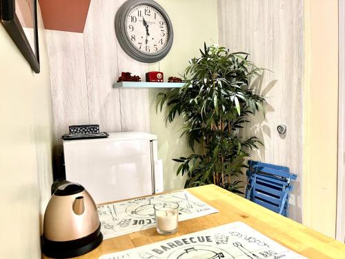 a clock hanging on a wall above a table with a clock at Petit Cocon cosy au cœur du village d'Allauch in Allauch