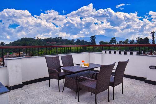 eine Terrasse mit einem Tisch und Stühlen auf dem Balkon in der Unterkunft Hotel Grand View in Kathmandu